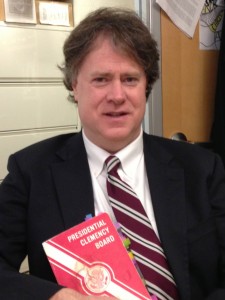 Clemency expert Mark Osler poses with book of historic clemency proceedings from the Ford Administration        